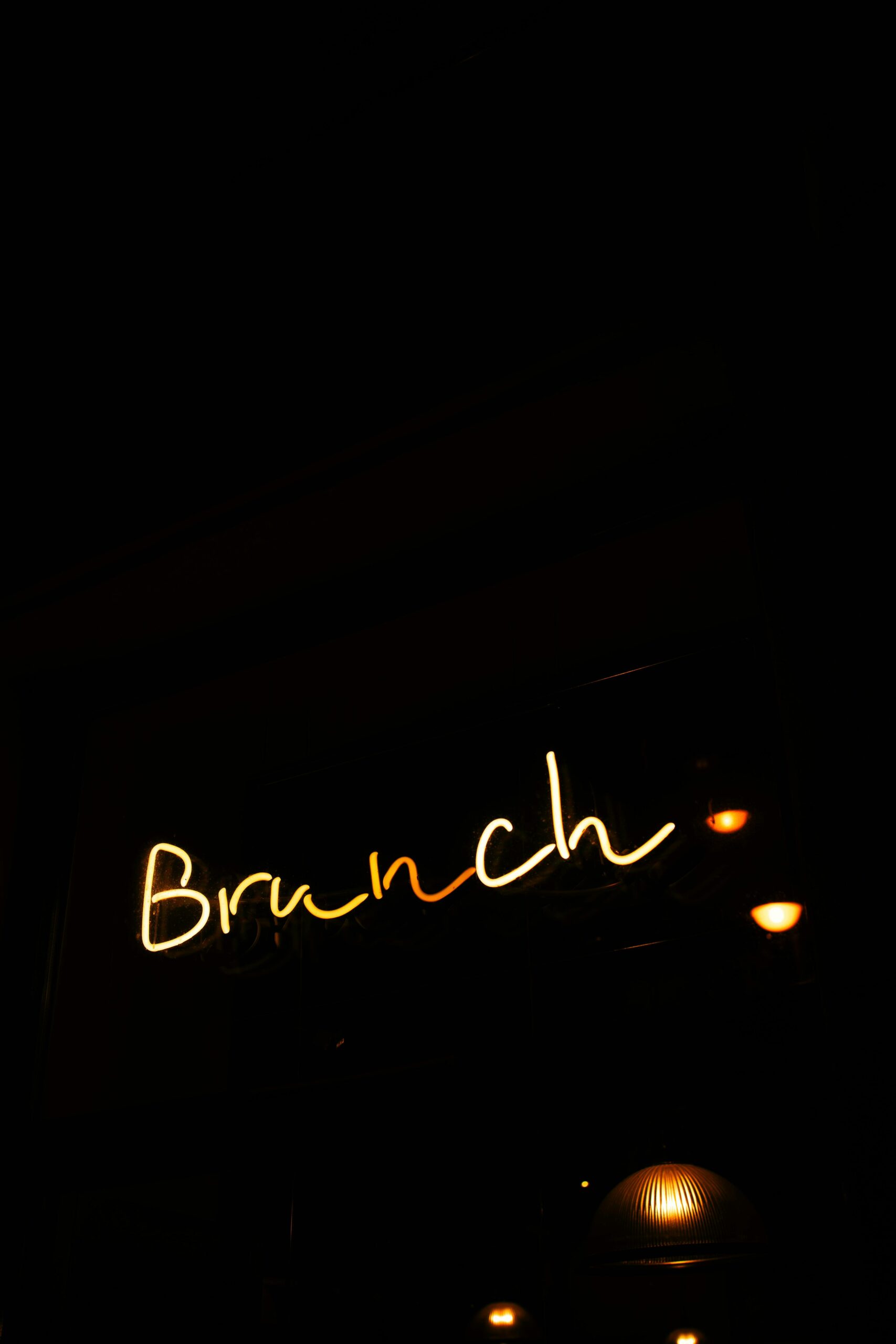 Neon sign displaying the word 'Brunch' glowing in a dimly lit environment.